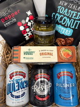 Load image into Gallery viewer, Assorted snacks and drinks including beer cans and a box of crackers in a basket.
