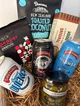 Load image into Gallery viewer, Assorted snacks and drinks including crackers, beer, and peanuts in a basket.
